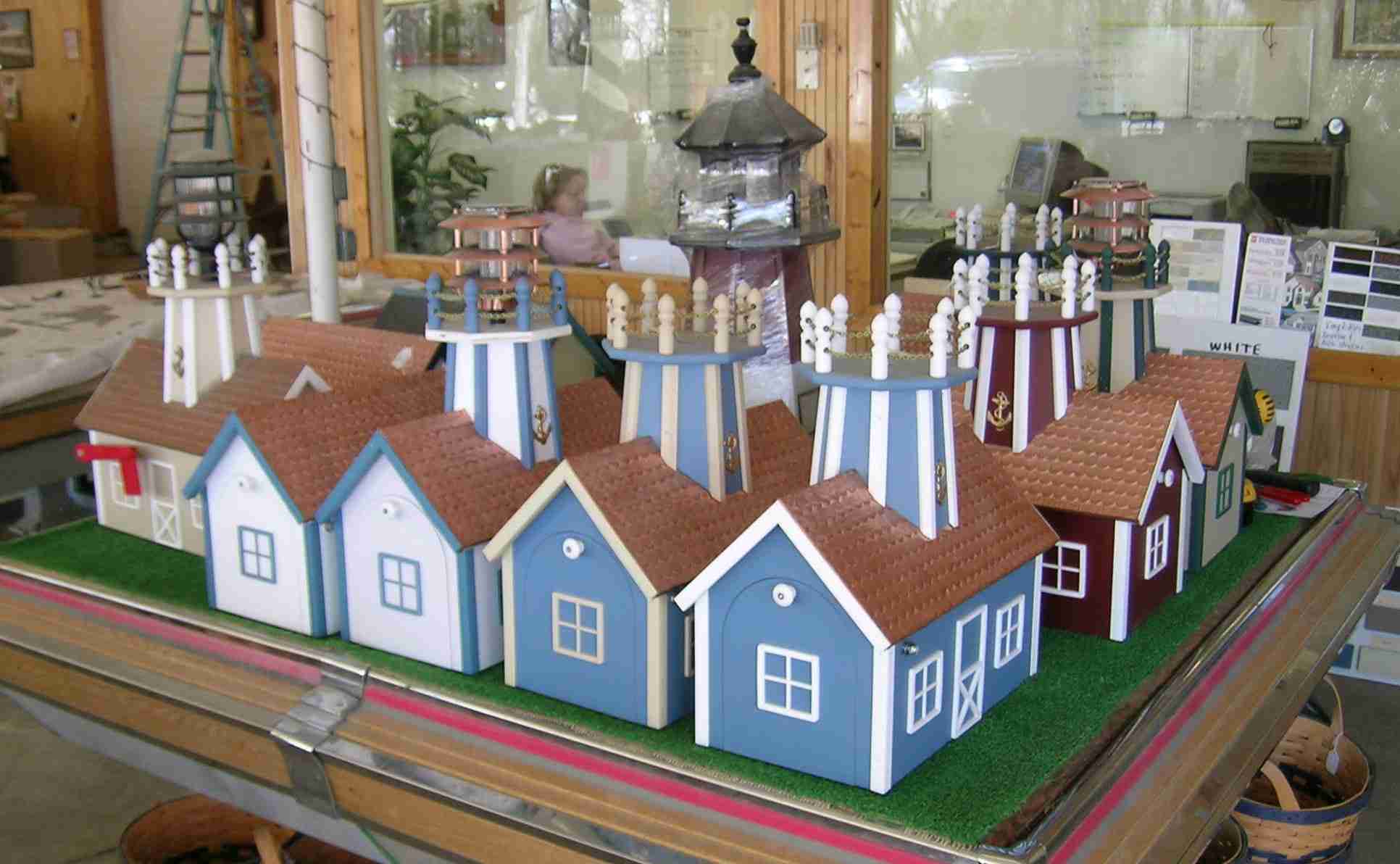 Table full of mailboxes with copper plate roofs.